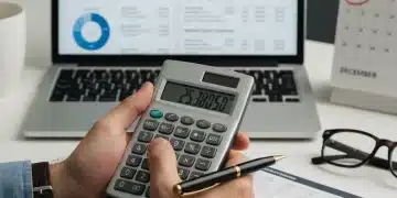 Cut Student Loan Debt: 4 Steps for 20% Reduction by 2026 Person calculating student loan payments with a calculator and financial documents.